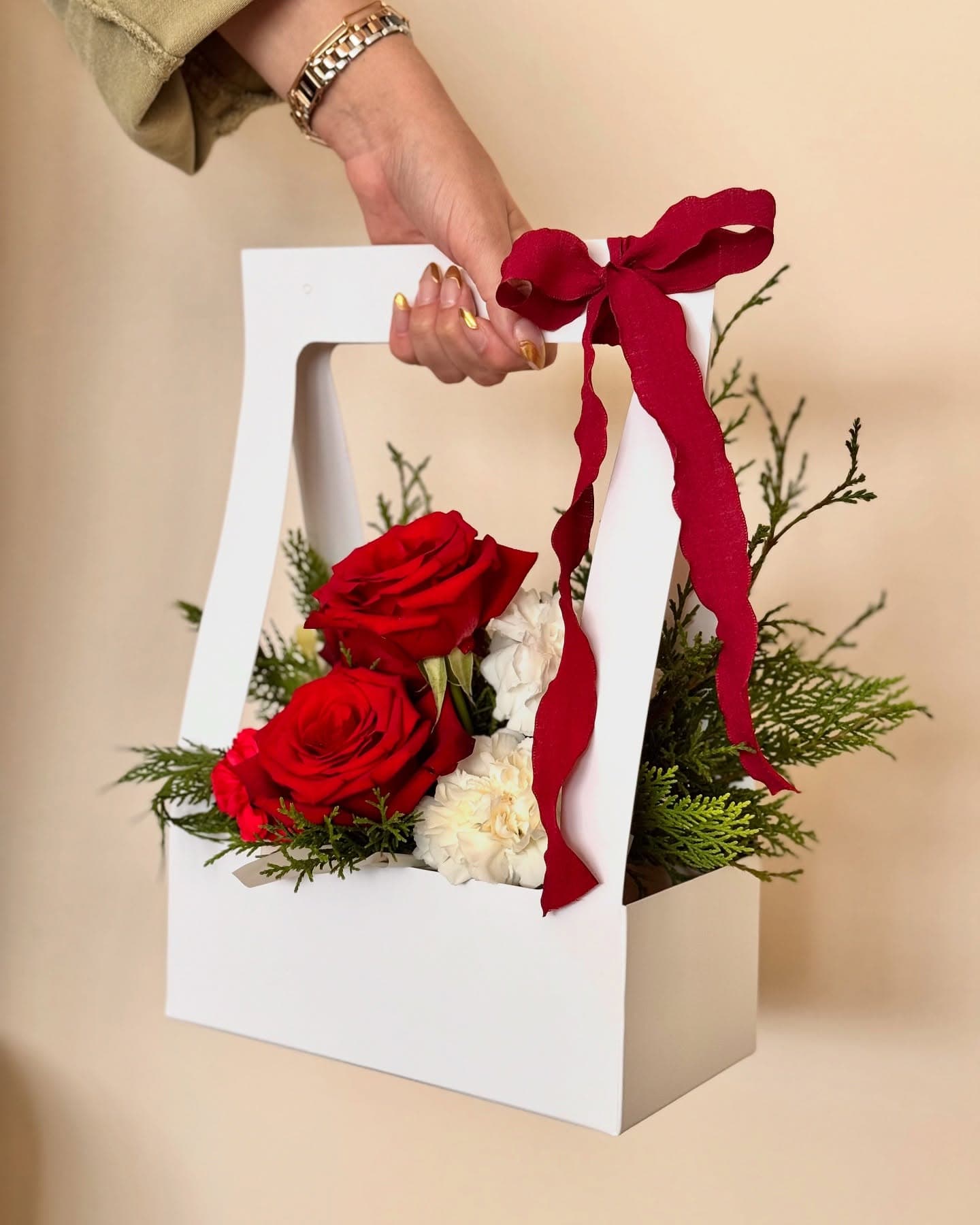 Canasta decorativa con rosas rojas y lazo rojo